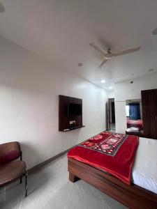 a bedroom with a bed and a chair in it at Jalsa hotel in Raipura