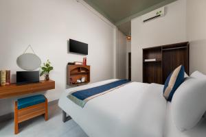 a bedroom with a bed and a desk and a television at CATBA HEVEN HILLs in Xuan Dam