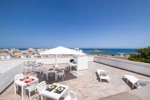 a patio with tables and chairs and an umbrella on a roof at Le 3 Viste B&B in Vieste