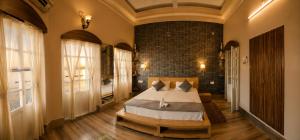 a bedroom with a bed and a brick wall at Shiva Ganges View Guest House in Varanasi +50 photos
