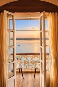 an open door to a balcony with a view of the ocean at Shiva Ganges View Guest House in Varanasi