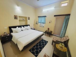 a bedroom with a large white bed and a window at Liliyan Palace Guest house in Jodhpur
