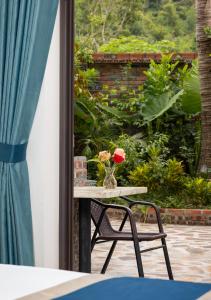 a table with a vase with a flower on it at CATBA HEVEN HILLs in Xuan Dam