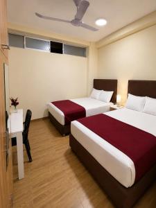 a hotel room with two beds and a desk at GRAND HOTEL ViLLA ROSA in Tingo María