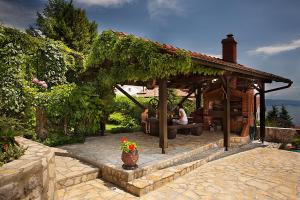a group of people sitting in a gazebo at Apartments Petricic with swimming pool in Ičići