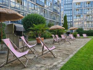 a group of lawn chairs and umbrellas in front of a building at Pullman Munich in Munich