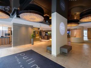 a lobby of a hotel with a sign on the floor at Pullman Munich in Munich