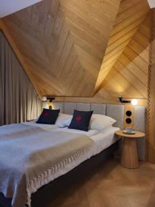 a bedroom with a large bed with a wooden ceiling at Jedla Miejsce Gościnne blisko term in Bukowina Tatrzańska +84 photos