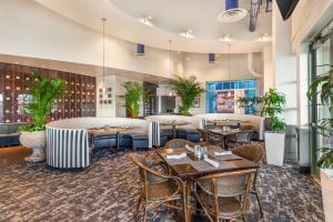 a restaurant with tables and chairs and plants at Hilton Virginia Beach Oceanfront in Virginia Beach