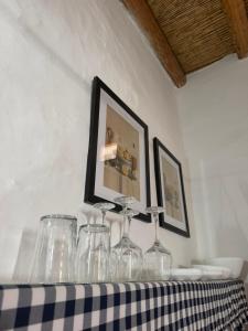 a table with wine glasses and pictures on the wall at Kamara since 1900 in Archangelos