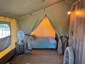 a bedroom in a tent with a bed in it at Camping Les Chagnelles in Le Perrier