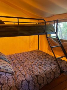 a bedroom with a bunk bed in a tent at Camping Les Chagnelles in Le Perrier