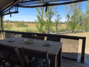 a wooden table on a deck with a view of a field at Camping Les Chagnelles in Le Perrier +202 photos