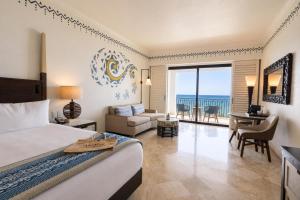 a hotel room with a bed and a view of the ocean at Hilton Los Cabos in San José del Cabo