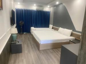 a bedroom with a bed and a blue curtain at Công Đoàn Hotel in Hai Phong +13 photos
