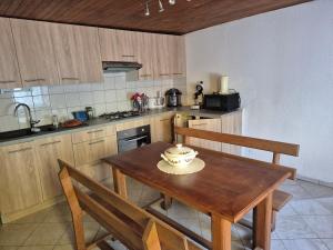 a kitchen with a wooden table with two chairs and a tableablish at La cabane de Claude in Fougerolles
