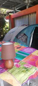 a tent with a lamp on top of a blanket at Banian Camping petit déjeuner offert in Bora Bora