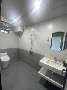 a bathroom with a toilet and a sink and a mirror at Công Đoàn Hotel in Hai Phong