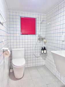 a bathroom with a toilet and a red window at Maison de Jann in Seoul +14 photos