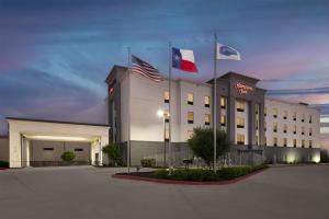 ein Hotel mit zwei Flaggen darauf in der Unterkunft Hampton Inn Cotulla in Cotulla