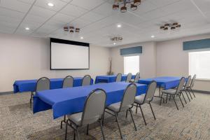 ein Konferenzraum mit blauen Tischen und Stühlen und einem Bildschirm in der Unterkunft Hampton Inn Cotulla in Cotulla + 22 Fotos