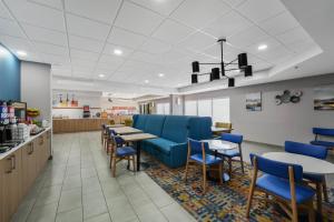 a waiting room with blue chairs and tables in a restaurant at Hampton Inn Henderson in Henderson