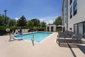 a swimming pool with lounge chairs next to a building at Hampton Inn Henderson in Henderson