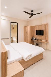 a bedroom with a large bed and a tv at Hotel 33 Inn in Kānpur