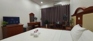 a bedroom with a white bed and a television at Công Đoàn Hotel in Hai Phong