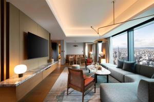 a living room with a couch and a tv at Conrad Nagoya in Nagoya