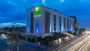 a building with a sign on it next to a street at Holiday Inn Express Mexico- Toreo by IHG in Mexico City