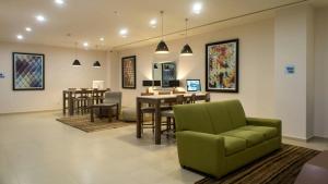 a living room with a green couch and a table and chairs at Holiday Inn Express Mexico- Toreo by IHG in Mexico City