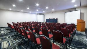 a conference room with red chairs and a podium at Holiday Inn Express Mexico- Toreo by IHG in Mexico City