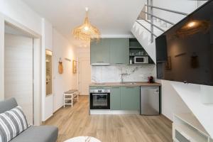 a kitchen with green cabinets and a staircase at Green Almond Residential Complex in Orfánion