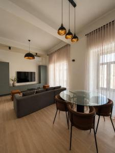 a living room with a glass table and a couch at Modern Designer Apartment Private Yard in Hamrun