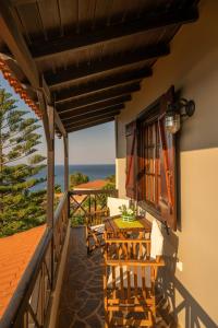 a balcony with a table and chairs and the ocean at Agnanti Seaview Villas in Karlovasi