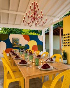 a dining room with a wooden table and yellow chairs at Hebron Gardens House in Kandy