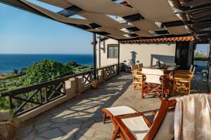 a patio with a table and chairs and the ocean at Agnanti Seaview Villas in Karlovasi
