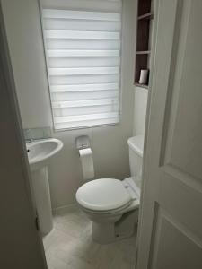 a bathroom with a toilet and a sink and a window at Nancy staycation in Clacton-on-Sea +6 photos