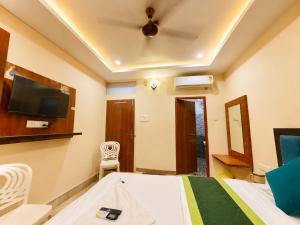 a bedroom with a bed and a tv on the wall at Hotel R GUEST HOUSE - NEAR KASHI VISHWANATH TEMPLE in Varanasi +14 photos