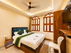 a bedroom with a bed with a ceiling fan at Hotel R GUEST HOUSE - NEAR KASHI VISHWANATH TEMPLE in Varanasi