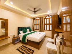 a bedroom with a bed and a television in it at Hotel R GUEST HOUSE - NEAR KASHI VISHWANATH TEMPLE in Varanasi