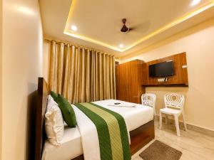 a hotel room with a bed and a table at Hotel R GUEST HOUSE - NEAR KASHI VISHWANATH TEMPLE in Varanasi