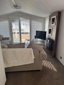 a living room with a couch and a flat screen tv at Nancy staycation in Clacton-on-Sea