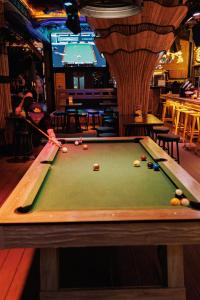 a man is playing pool in a bar at Sea Beach Hostel & Club Beachfront 18-39 years only in Ao Nang Beach