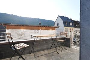 a table and chairs on a balcony with a boat at MoselStudio Briedel - Sonnenterrasse und Komfort in Briedel