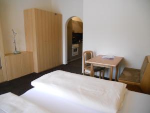 レルモースにあるAppartementhaus Wetterlochのベッド、テーブル、キッチンが備わる客室です。