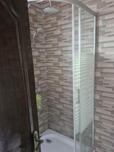 a shower with a glass door in a bathroom at Cosy Corner Villa in Lusaka