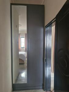 a mirror in a room with a bed and a bedroom at Cosy Corner Villa in Lusaka