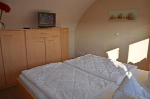 a bedroom with a bed and a television on a dresser at Bella Casa 35 in Juliusruh